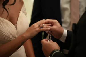 Un novio coloca el anillo de compromiso en la mano de su pareja