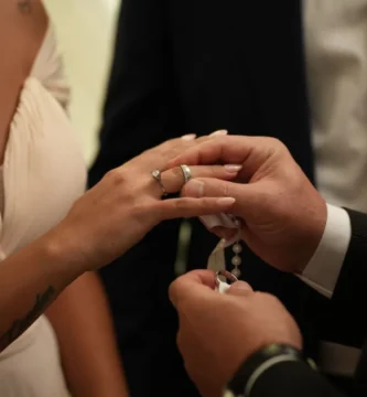 Un novio coloca el anillo de compromiso en la mano de su pareja