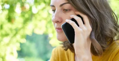 Mujer hablando por teléfono móvil con gesto pensativo