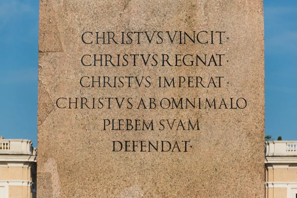 Inscripción latina en el pedestal del obelisco de la plaza de San Pedro del Vaticano