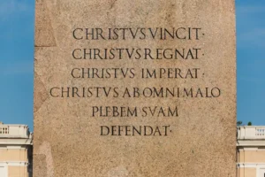 Inscripción latina en el pedestal del obelisco de la plaza de San Pedro del Vaticano