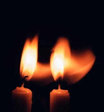 Dos velas encendidas en la oscuridad