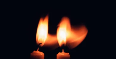 Dos velas encendidas en la oscuridad