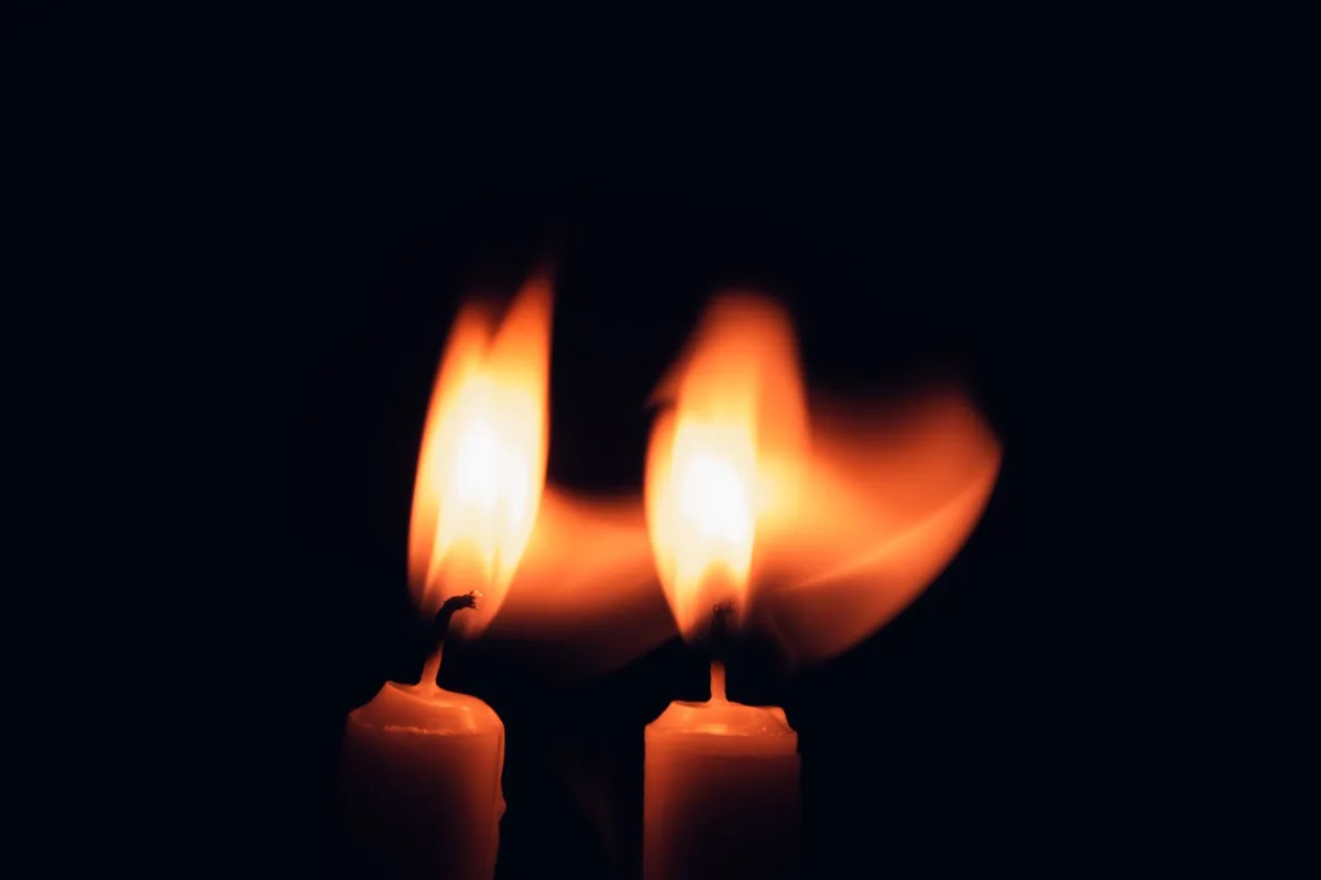 Dos velas encendidas en la oscuridad
